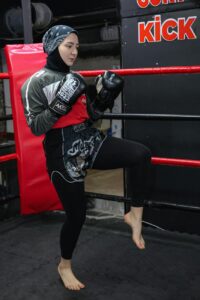 a woman in a black outfit is practicing boxing